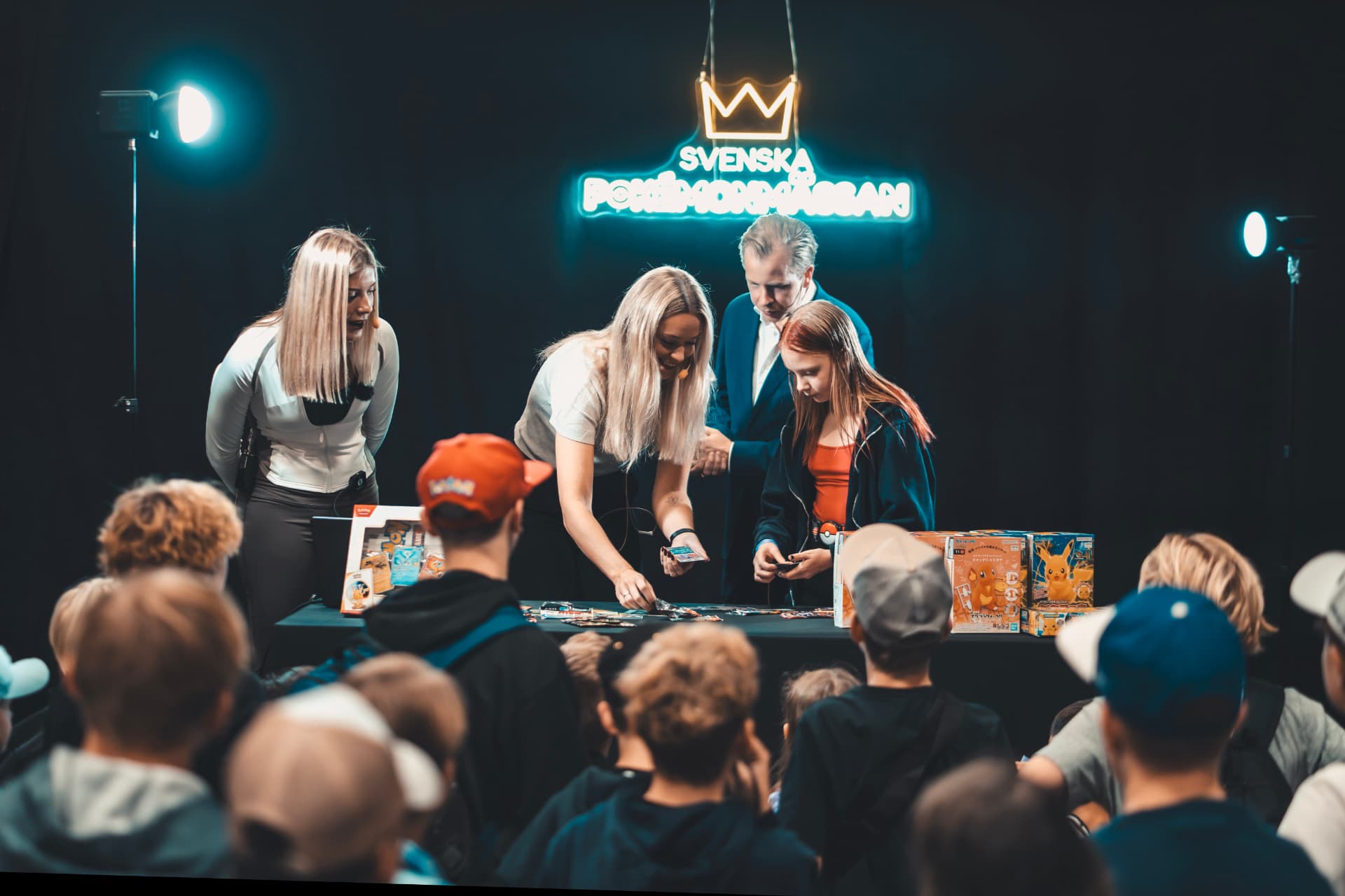 Kortöppning på scenen framför neonskylten Svenska Pokémonmässan